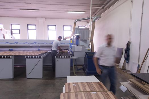 two worker working in a factory for the production of wooden furniture