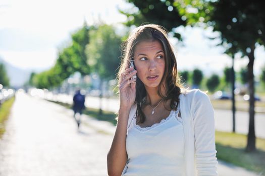 beautiful fit young woman talk by cellphone in city at street on sunny day