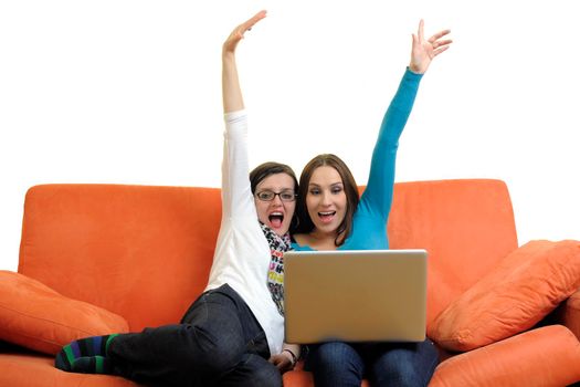 female friends relax and working on  laptop computer at home on orange sofa isolated on white backgrond