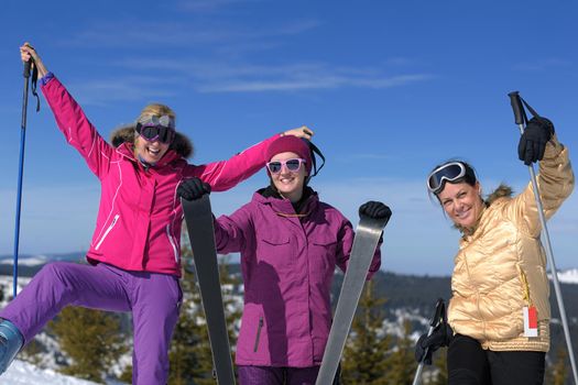 happy friends group of woman girls have fun at winter season at beautiful sunny  snow day with blue sky in background