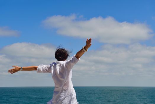 healthy Happy  young woman with spreading arms, blue sky with clouds in background  - copyspace