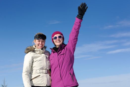 happy friends group of woman girls have fun at winter season at beautiful sunny  snow day with blue sky in background