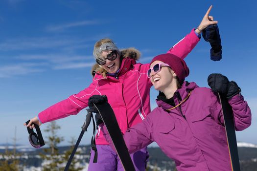 happy friends group of woman girls have fun at winter season at beautiful sunny  snow day with blue sky in background