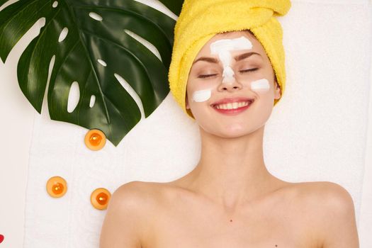 pretty woman face mask skin cleansing palm leaf light background. High quality photo