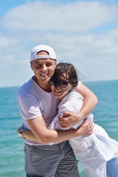 Smiling happy couple looking at camera together at summer beach