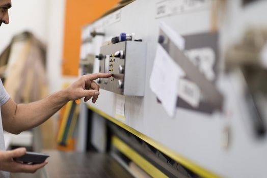 Young worker works in a factory for the production of wooden furniture