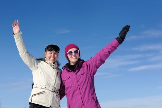 happy friends group of woman girls have fun at winter season at beautiful sunny  snow day with blue sky in background