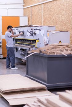 Young worker works in a factory for the production of wooden furniture