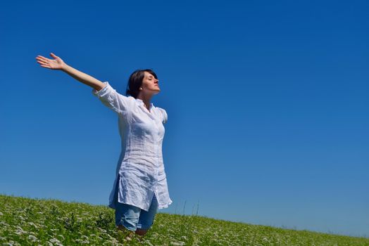 healthy Happy  young woman with spreading arms, blue sky with clouds in background  - copyspace