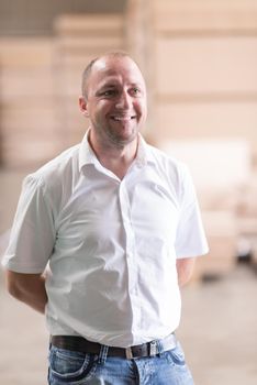 Portrait of an independent designer in his furniture manufacturing workshop, looking relaxed and confident