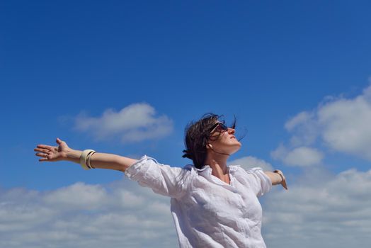 healthy Happy  young woman with spreading arms, blue sky with clouds in background  - copyspace