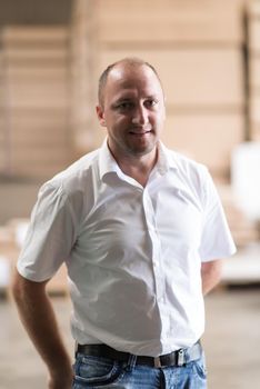 Portrait of an independent designer in his furniture manufacturing workshop, looking relaxed and confident