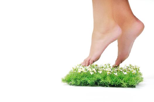 woman legs walking on small peace of green grass isolated on white representing last oasis concept