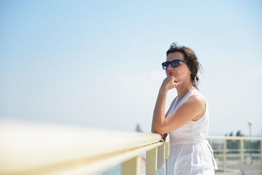 Happy  young woman with spreading arms, blue sky with clouds in background  - copyspace