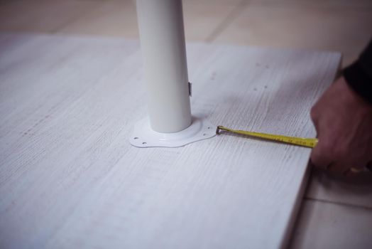 carpenter worker measuring distance for drilling holes in new furniture