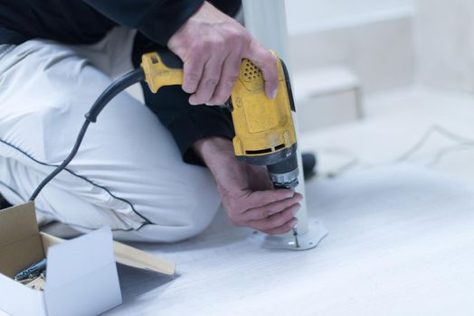 repairman working with drilling machine and assambling  furniture