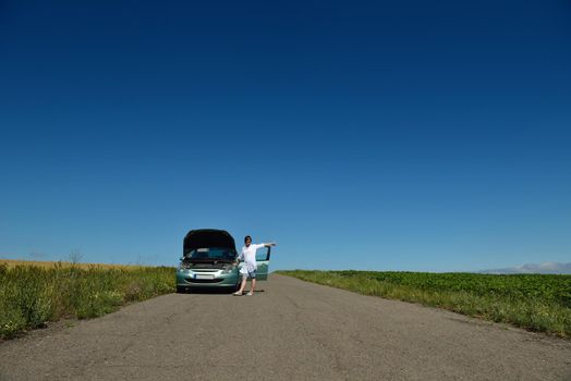 portrait of young beautiful woman with broken car outdoor