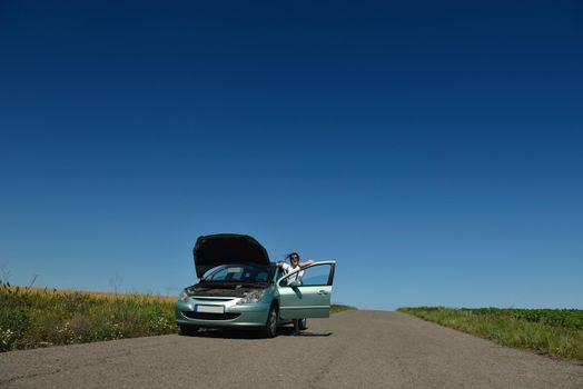 portrait of young beautiful woman with broken car outdoor