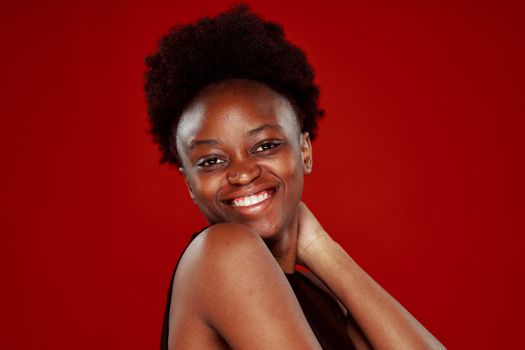 curly african woman in black t-shirt red background. High quality photo