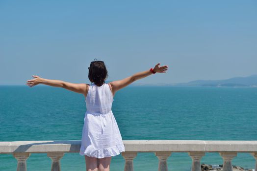 Happy  young woman with spreading arms, blue sky with clouds in background  - copyspace