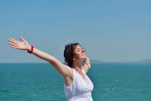 Happy  young woman with spreading arms, blue sky with clouds in background  - copyspace