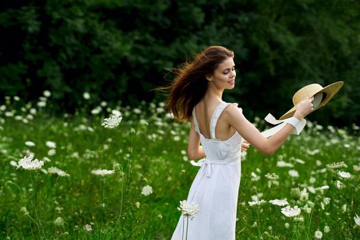 Woman in white dress hat nature field flowers. High quality photo