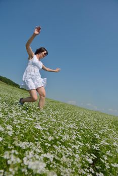 Young happy woman in green field with blue sky in background