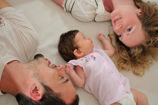 young family playing with cute little baby