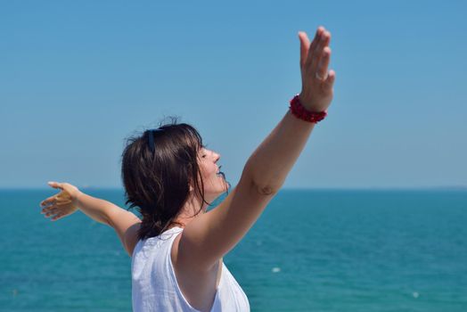 Happy  young woman with spreading arms, blue sky with clouds in background  - copyspace