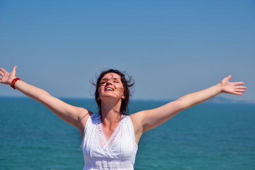healthy Happy  young woman with spreading arms, blue sky with clouds in background  - copyspace
