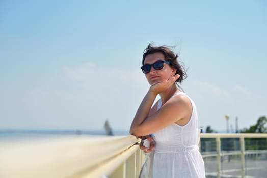 happy young tourist woman have fun while traveling araund city with blue sky and sea in background