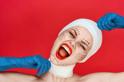a person in blue gloves syringe in hands contour on the face lifting red background. High quality photo