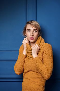 Studio portrait of a young woman in yellow pullover