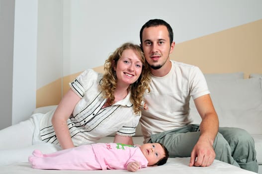 indoor portrait with happy young famil and  cute little babby 