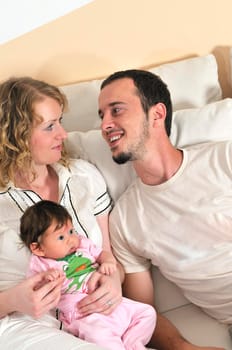 indoor portrait with happy young family and  cute little babby 