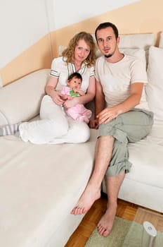 indoor portrait with happy young family and  cute little babby