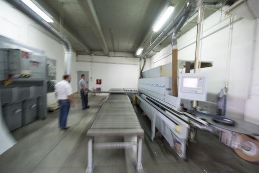 two worker working in a factory for the production of wooden furniture