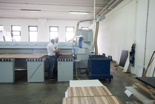 two worker working in a factory for the production of wooden furniture