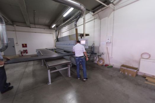 two worker working in a factory for the production of wooden furniture