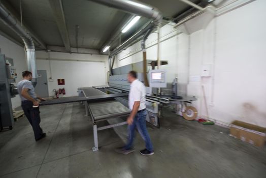 two worker working in a factory for the production of wooden furniture