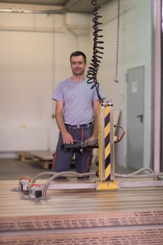 Young worker works in a factory for the production of wooden furniture