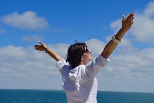 healthy Happy  young woman with spreading arms, blue sky with clouds in background  - copyspace