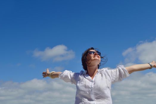 healthy Happy  young woman with spreading arms, blue sky with clouds in background  - copyspace