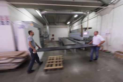 two worker working in a factory for the production of wooden furniture