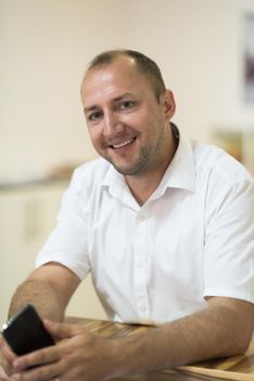 Portrait of an independent designer in his furniture manufacturing workshop, looking relaxed and confident