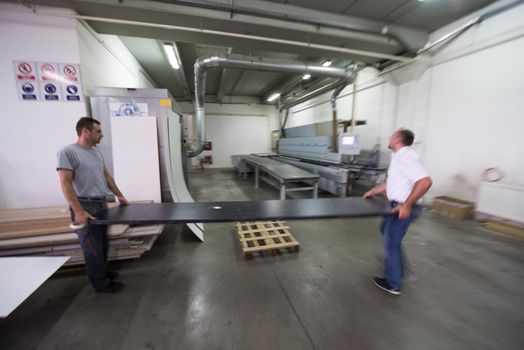 two worker working in a factory for the production of wooden furniture