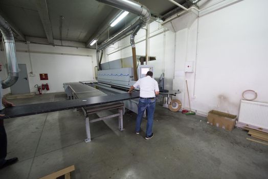 two worker working in a factory for the production of wooden furniture