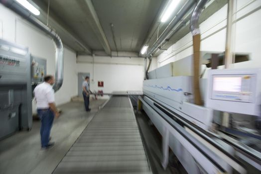 two worker working in a factory for the production of wooden furniture