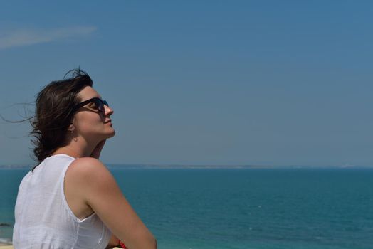 Happy  young woman with spreading arms, blue sky with clouds in background  - copyspace