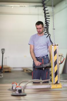 Young worker works in a factory for the production of wooden furniture